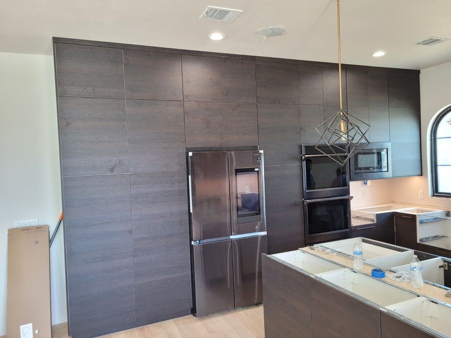 Floor-to-ceiling cabinetry wall with integrated appliances installed to plan by D&L Excellence Services